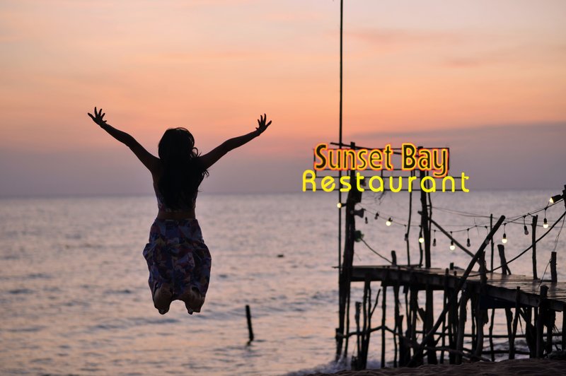 Woman jumping on beach, joyful